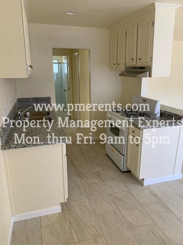 a kitchen with white cabinets and a counter top and a sink