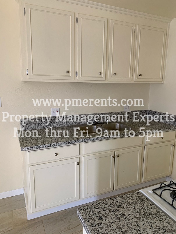 a kitchen with white cabinets and a counter top