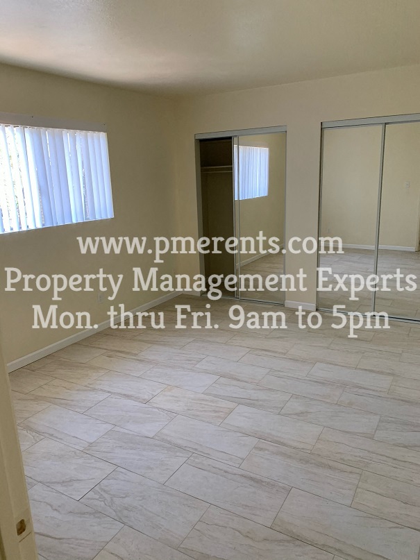 an empty living room with a door to a closet