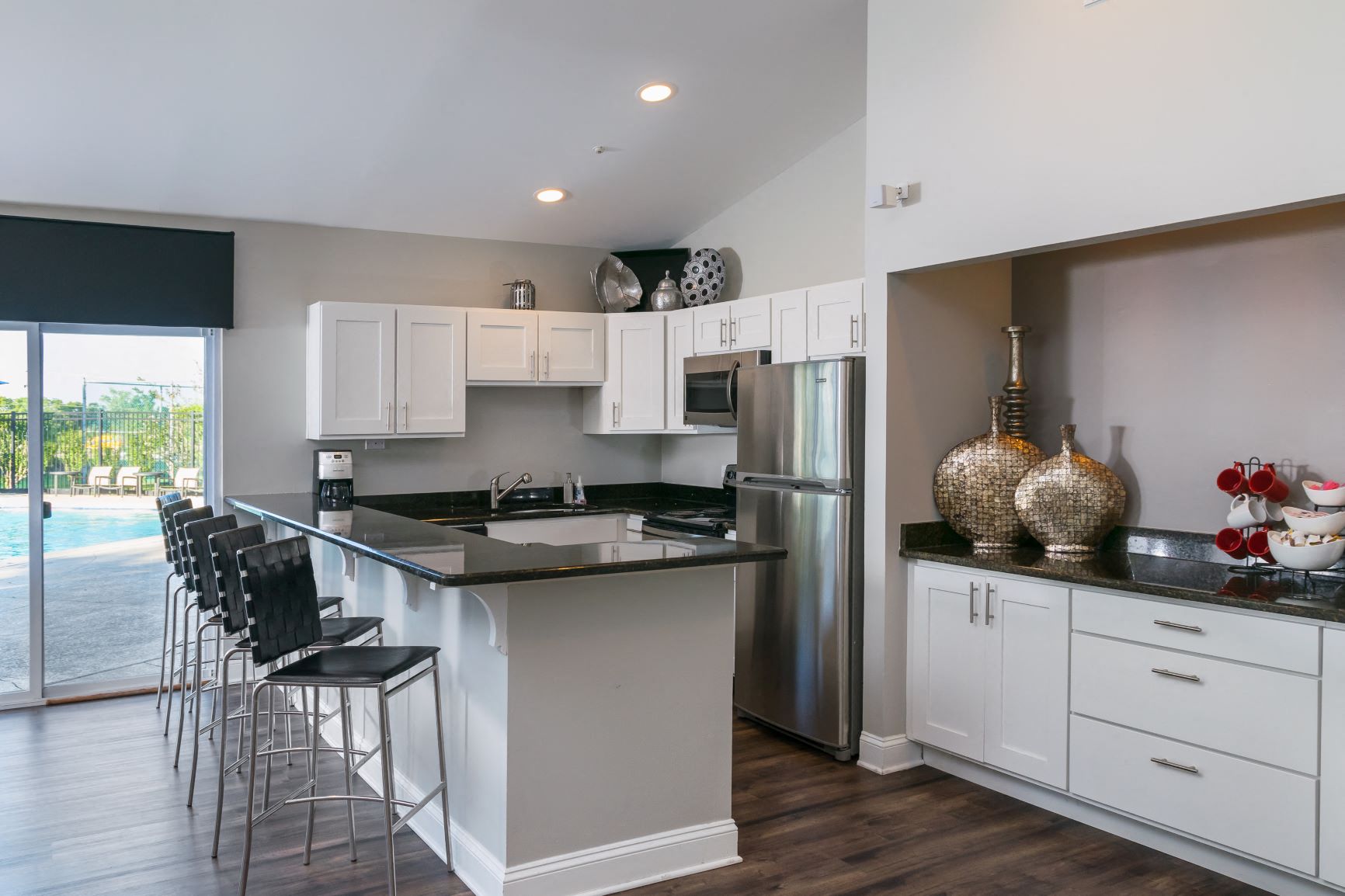 a kitchen with a large island and a stainless steel refrigerator