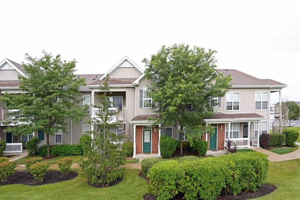 a house with a yard and trees in front of it