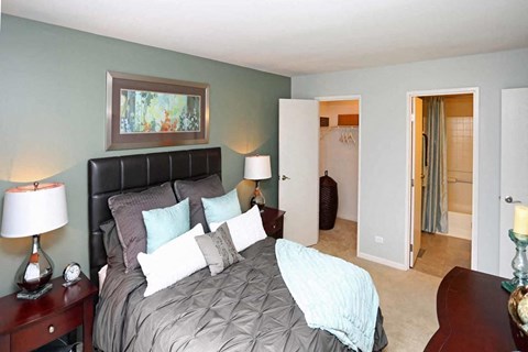 a bedroom with a large bed and a door to a bathroom