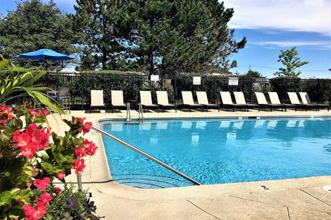 Apartment swimming pool with lounge chairs around it