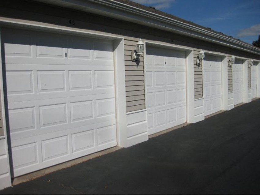 a row of white garage doors on the side of a building