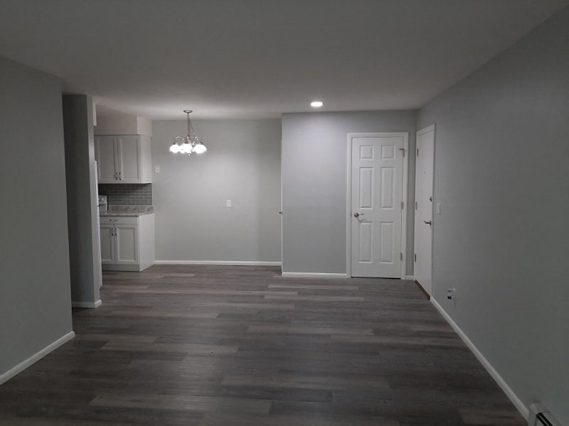 A room with a white door and a chandelier.
