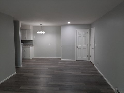 A room with a white door and a chandelier.