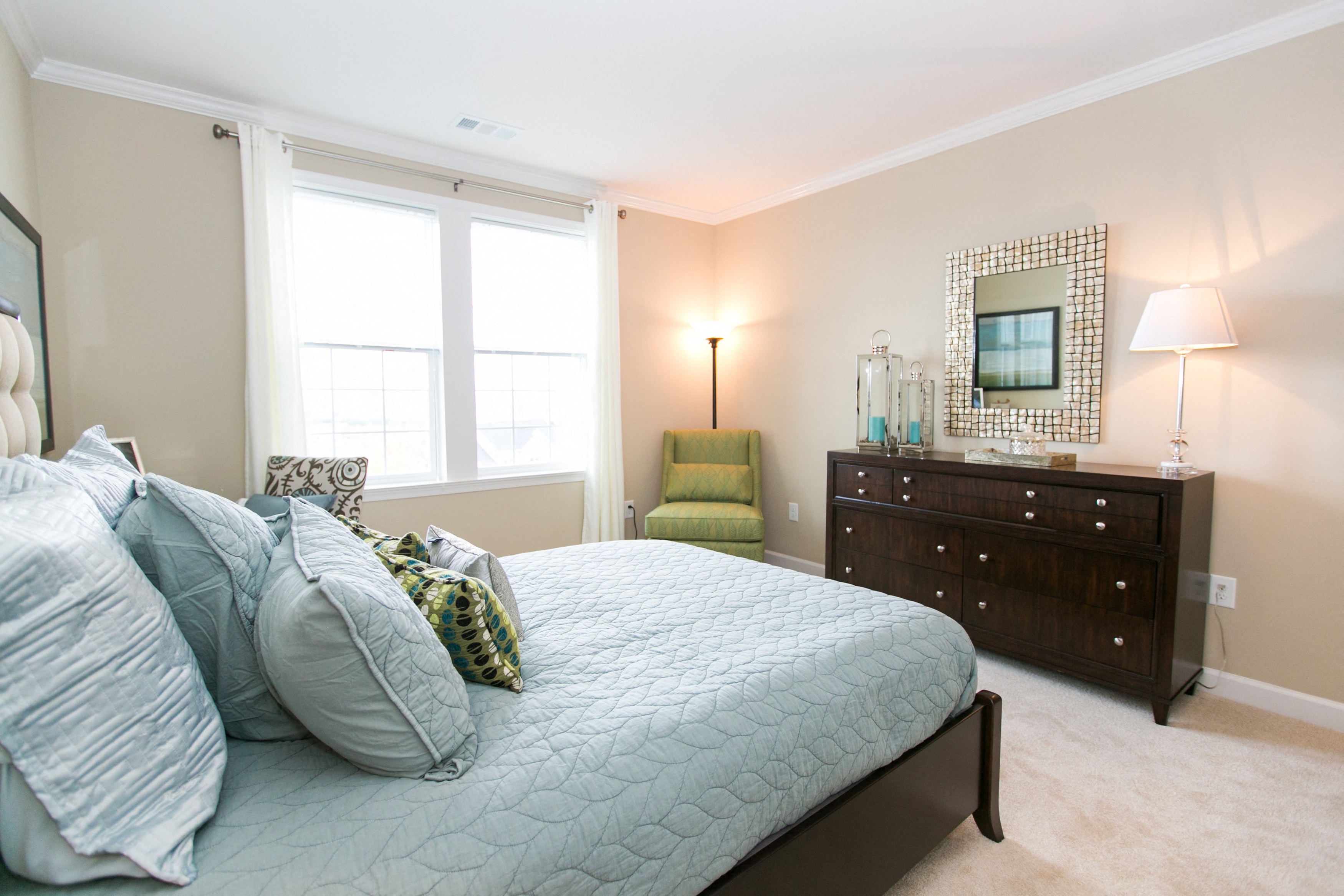 bedroom at VistaView apartments in Frederick, MD with bed with blue linens, dresser and chair at VistaView, Maryland, 21702
