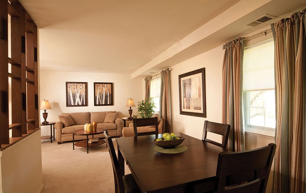 a living room and dining room with a table and chairs