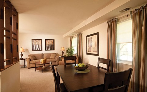 a living room and dining room with a table and chairs