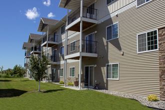 Exterior of Amber Ridge Apartments in Fargo ND with a green lawn and trees.