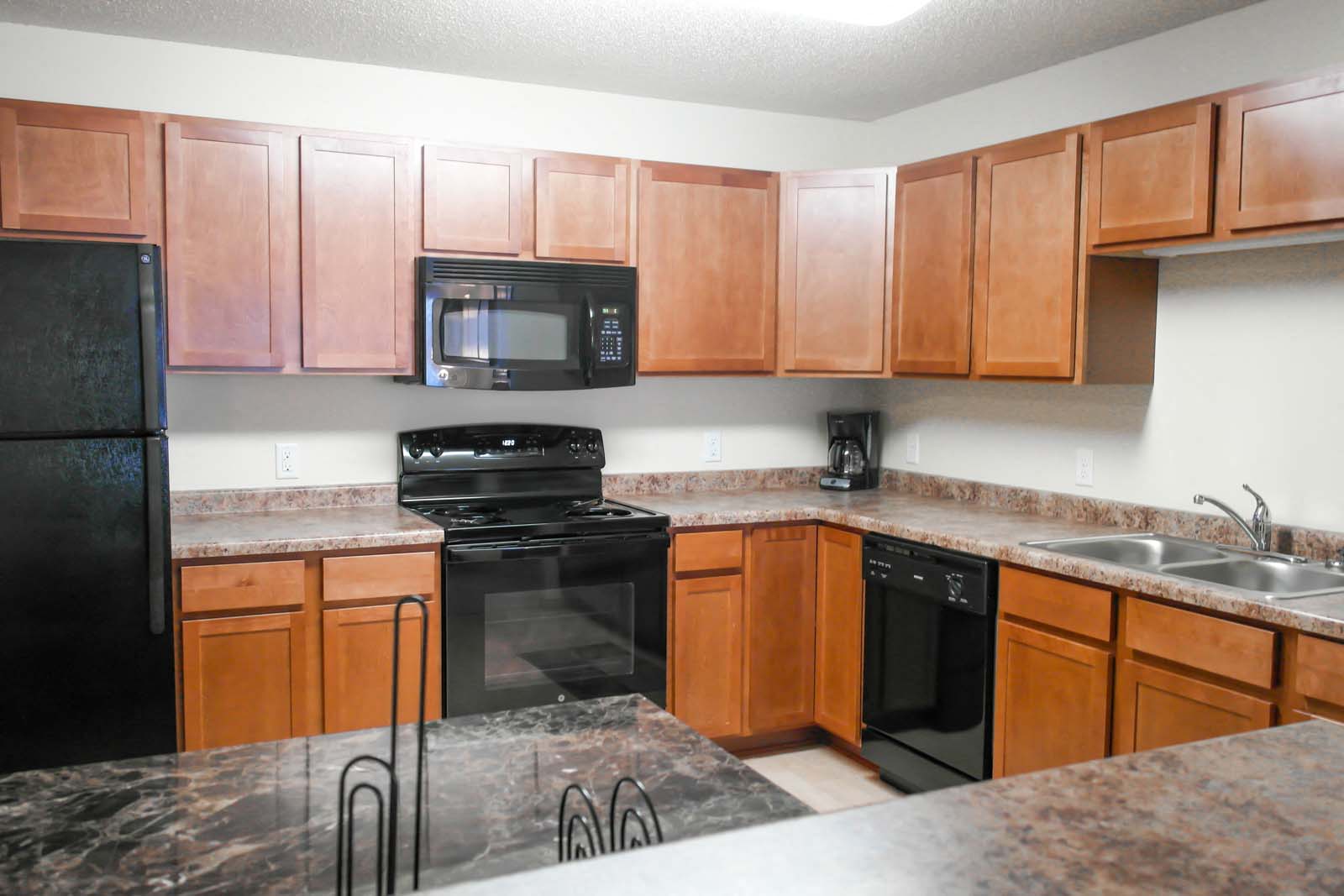 Full kitchen with black appliances and dining room at Amber Ridge Apartments in Fargo ND.