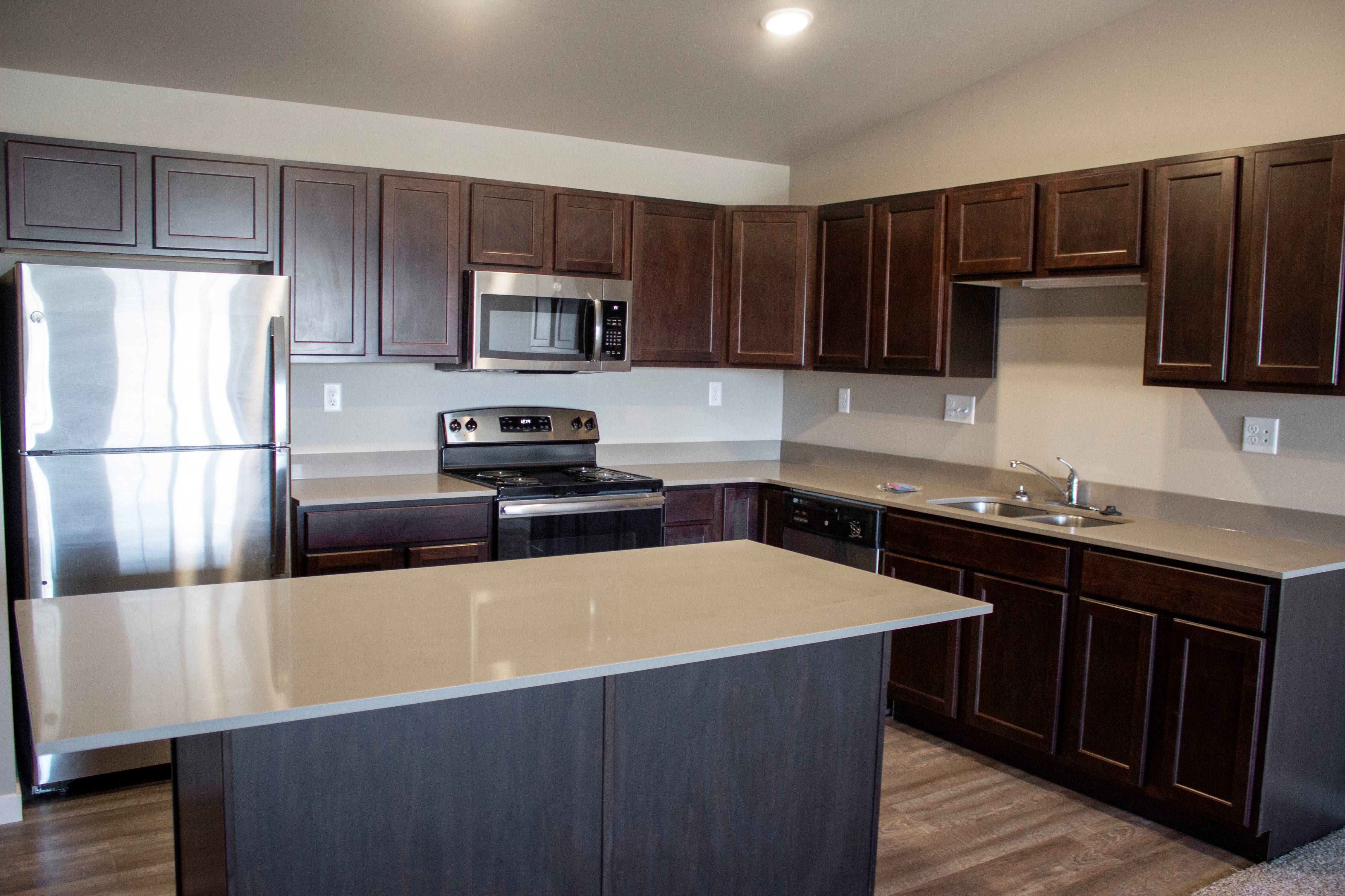 a kitchen with wooden cabinets and stainless steel appliances