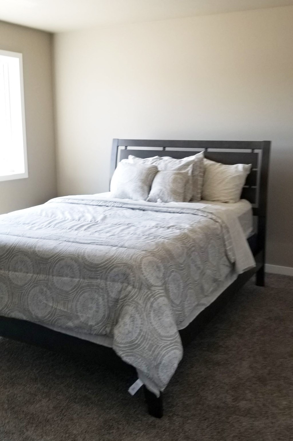 a bedroom with a bed with white sheets and pillows