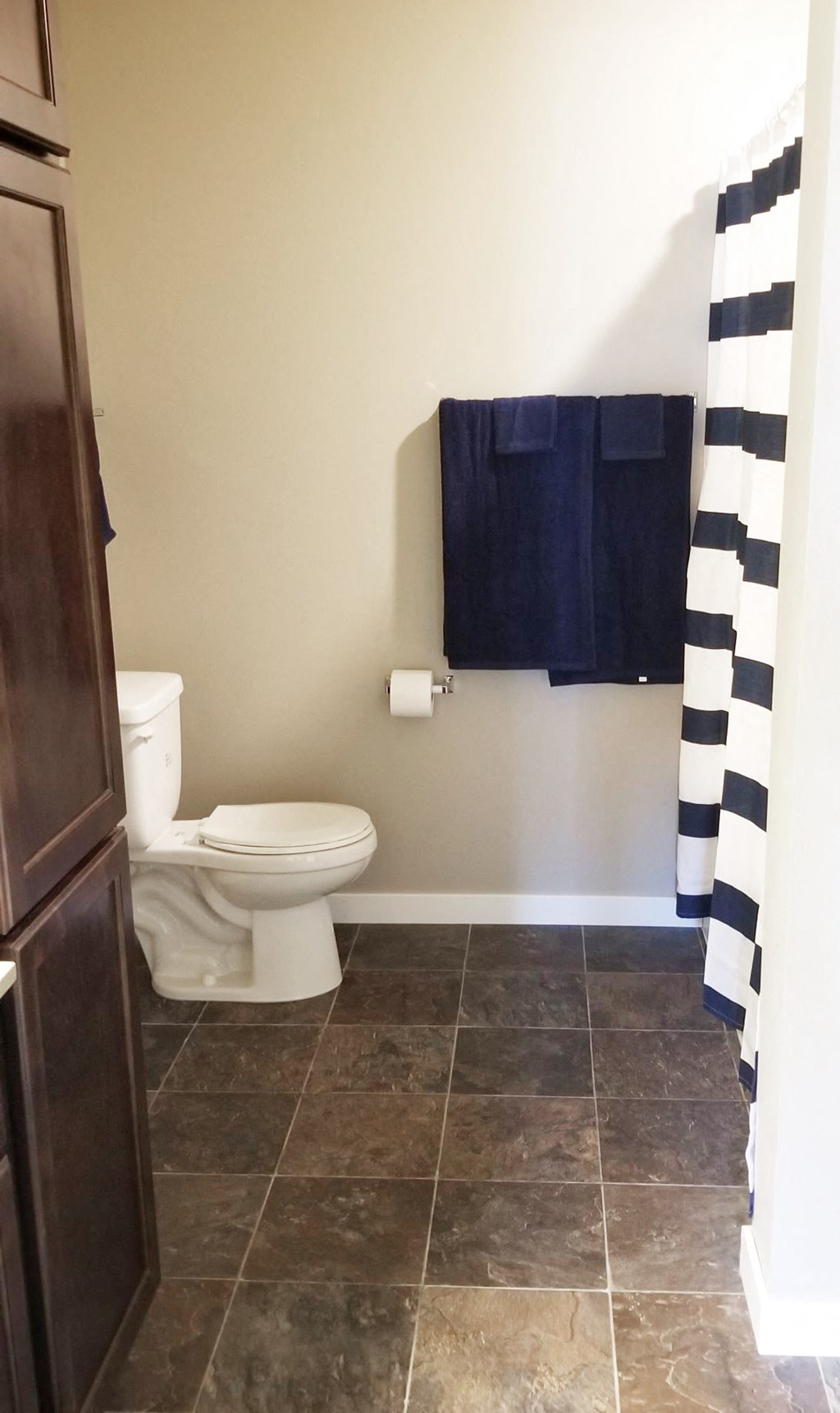 a bathroom with a toilet and a black and white shower curtain