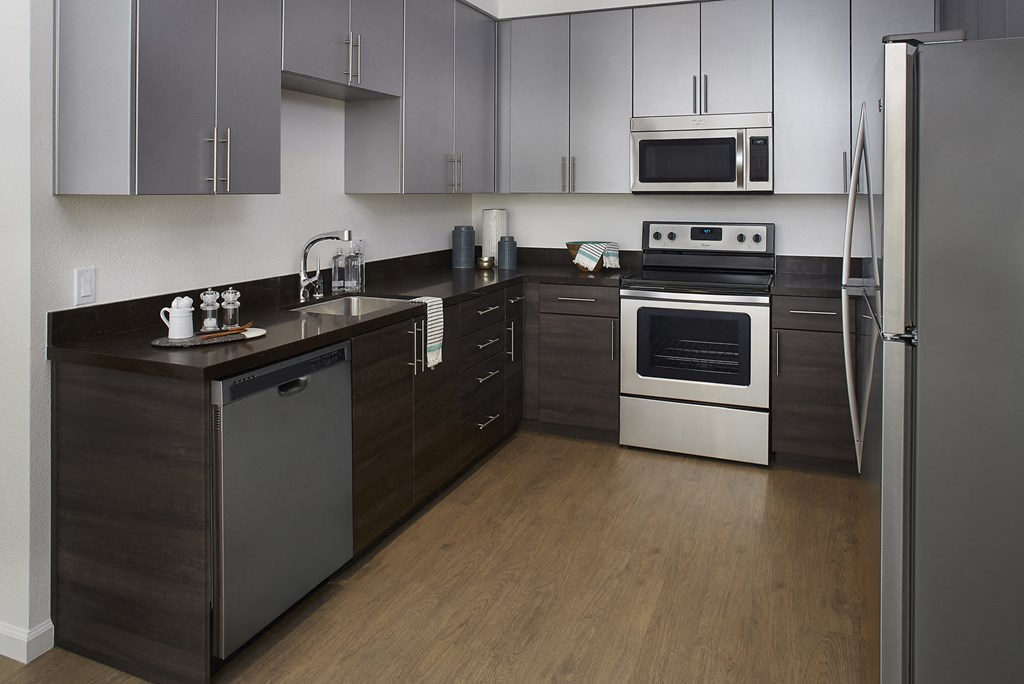 San Jose, CA Apartments For Rent - Kitchen With Wood-Plank Flooring, Dishwasher, Oven, Microwave, Refrigerator, Quartz Countertops, And Two Tone Cabinetry.