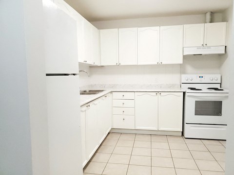 a white kitchen with white appliances and white cabinets