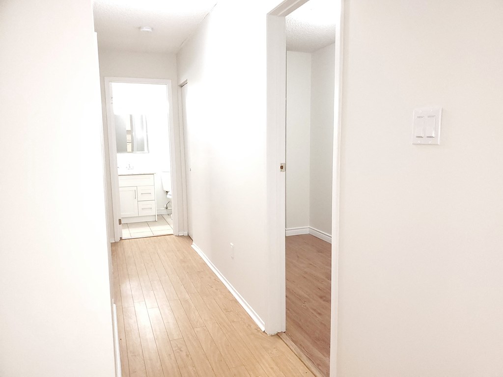 an empty room with white walls and a wooden floor