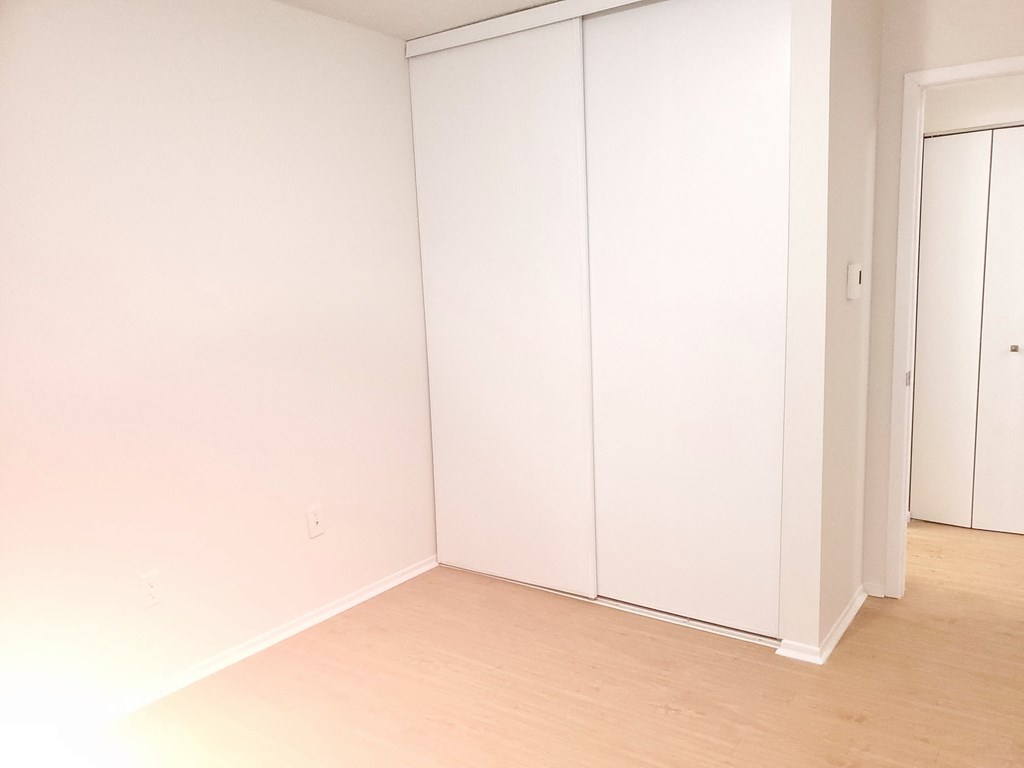 an empty room with white walls and a wood floor
