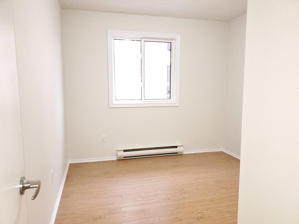 an empty room with a radiator and a window