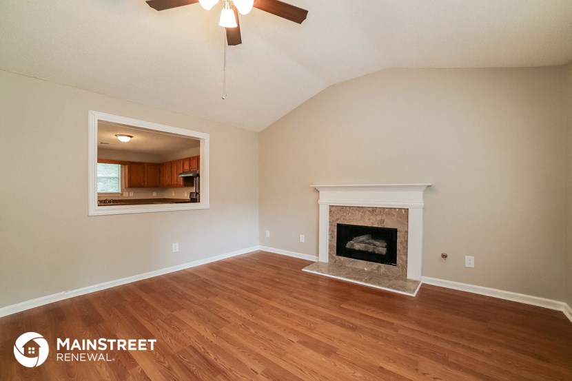 the living room with fireplace and wood flooring