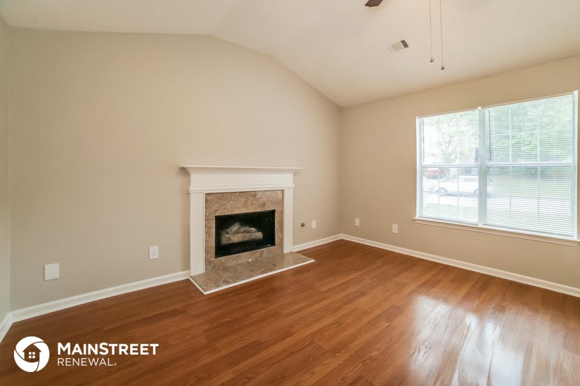 the living room with fireplace and wood flooring