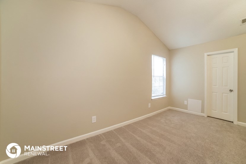 the upstairs bedroom with carpet and a white door