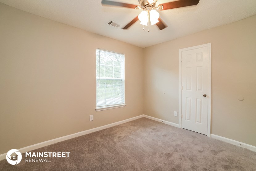 the upstairs bedroom with carpet and a ceiling fan