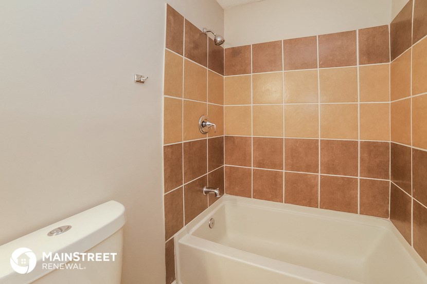 a tiled bathroom with a bath tub and a toilet