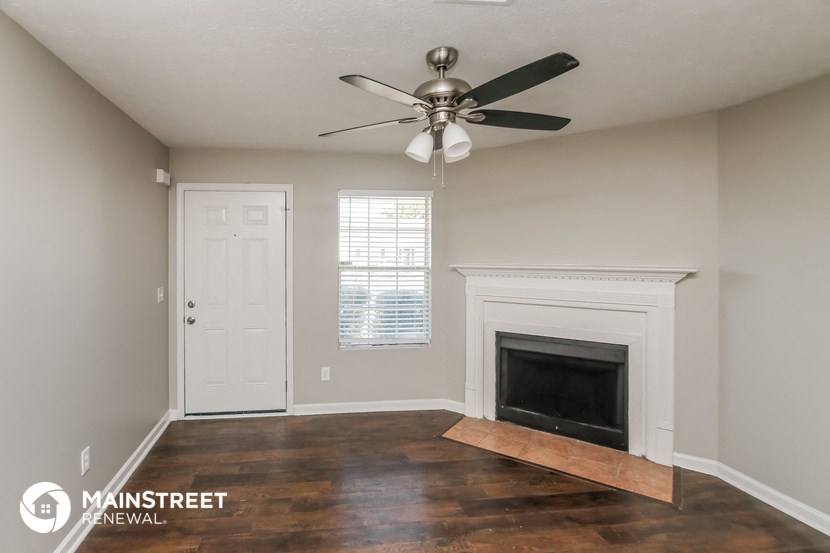 the living room with fireplace and ceiling fan