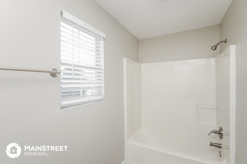 a bathroom with a tub and a shower and a window
