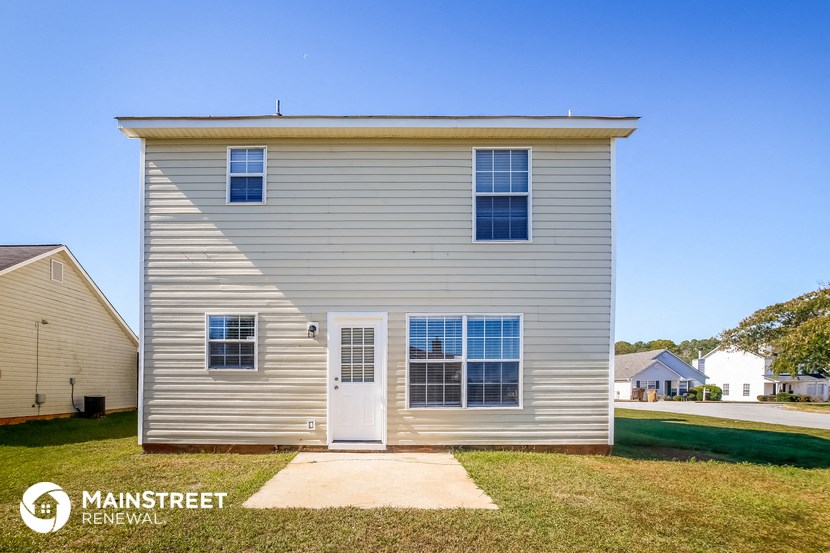 a small white house with white siding and a white front door