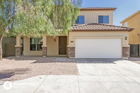 a house with a white garage door and a tree