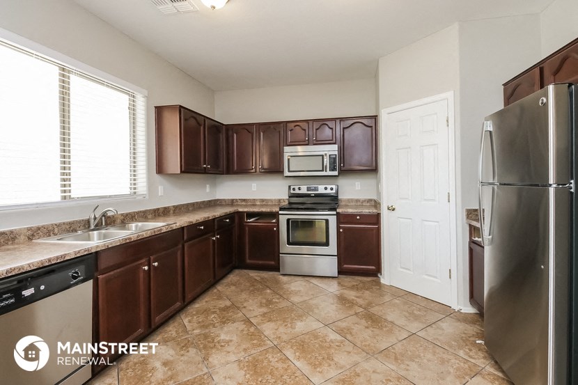 a kitchen with wooden cabinets and stainless steel appliances