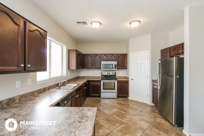 a large kitchen with stainless steel appliances and marble counter tops