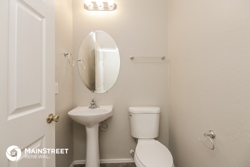 a white bathroom with a sink toilet and a mirror