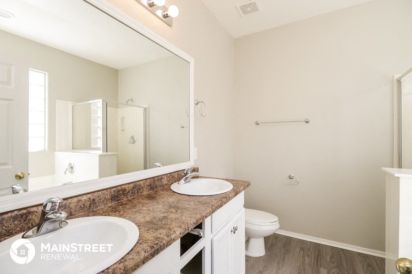 a bathroom with two sinks and a toilet and a large mirror