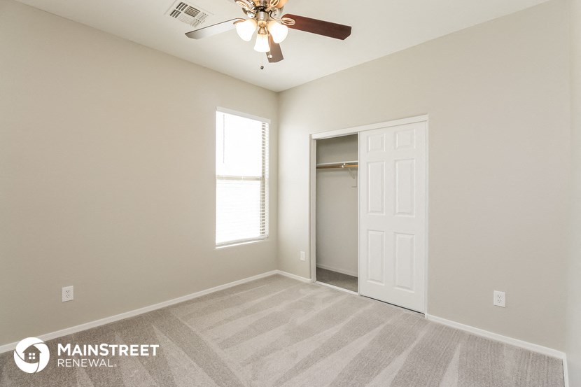 an empty room with a ceiling fan and a closet