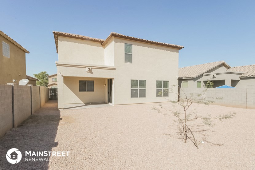 a white house with a dirt driveway in front of it