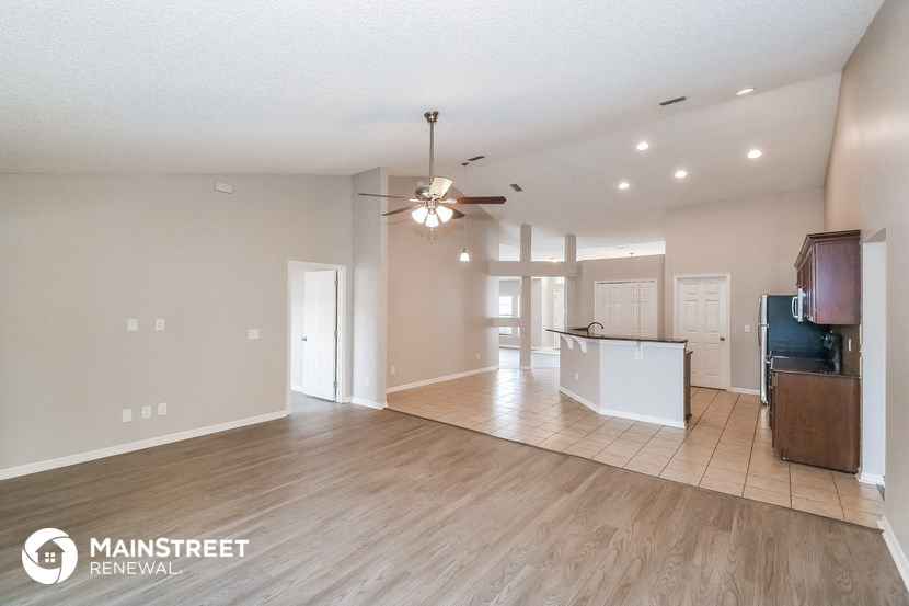 an open living room and kitchen with a ceiling fan