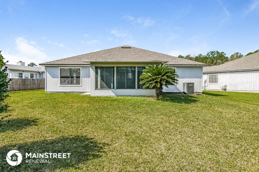 a home with a grass yard and a palm tree