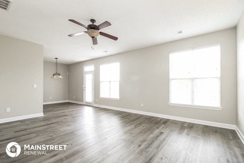 the living room of a new home with a ceiling fan