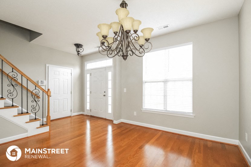 a living room with a staircase and a chandelier