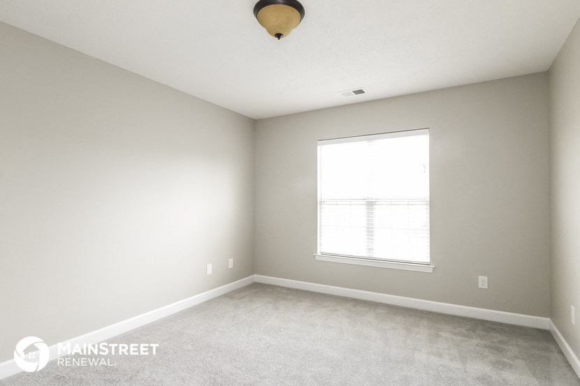 a white room with a window and a white carpet