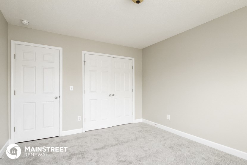 a bedroom with two white doors and a carpeted floor