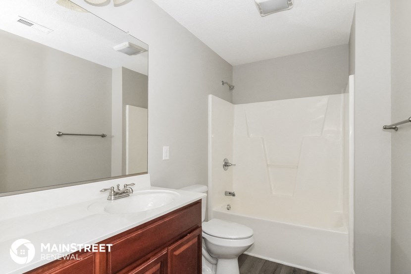 a bathroom with a sink toilet and a mirror
