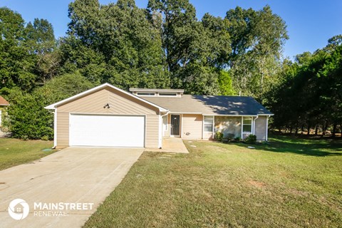 a small tan house with a white garage door