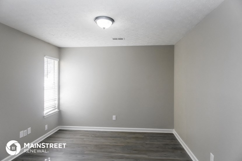 the interior of an empty room with gray walls and a window