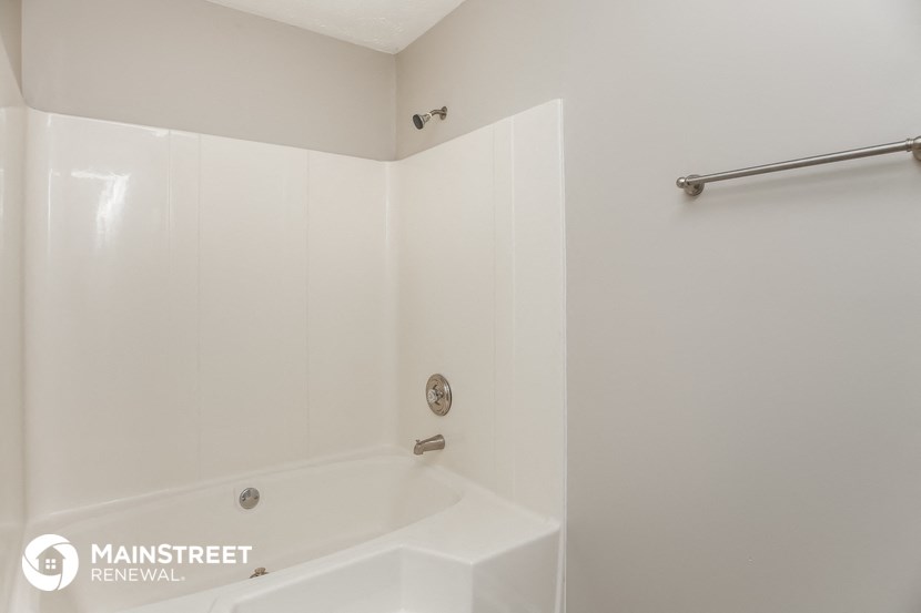 a white bathroom with a tub and a shower curtain