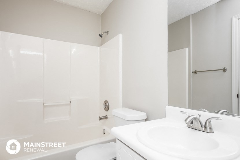 a white bathroom with a sink and a tub and a toilet