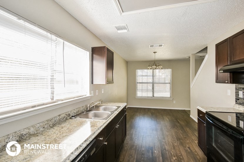 a kitchen with granite countertops and a large window